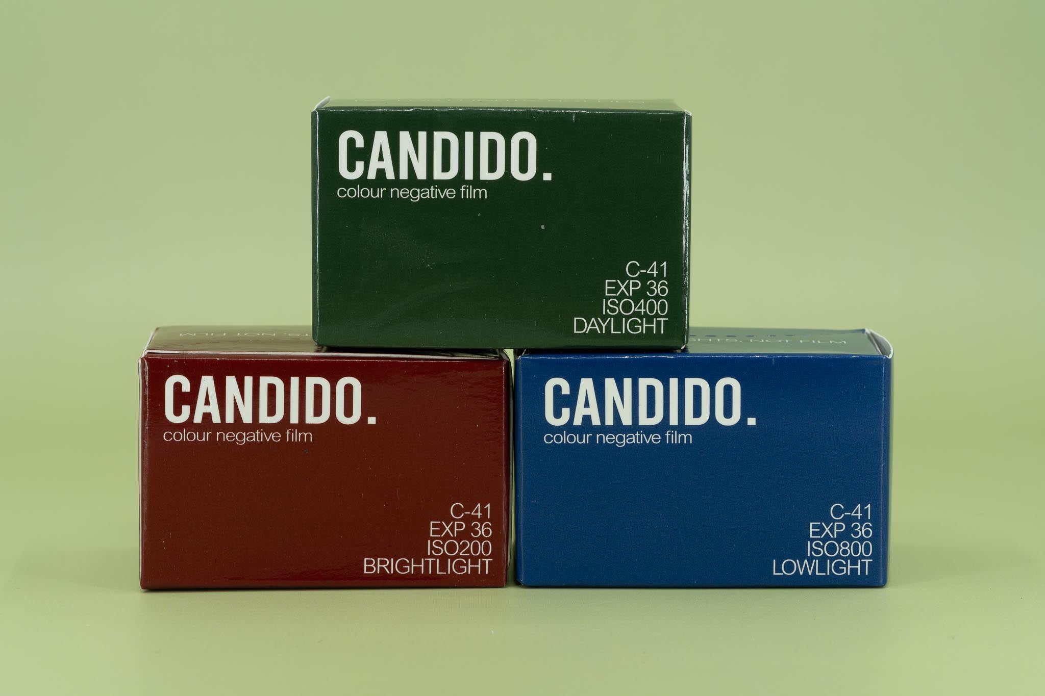 Three boxes of Candido color negative film on a green background