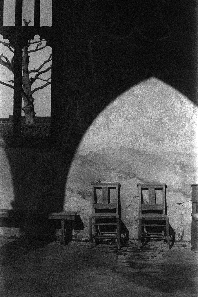 Black and white interior scene with chairs and a window