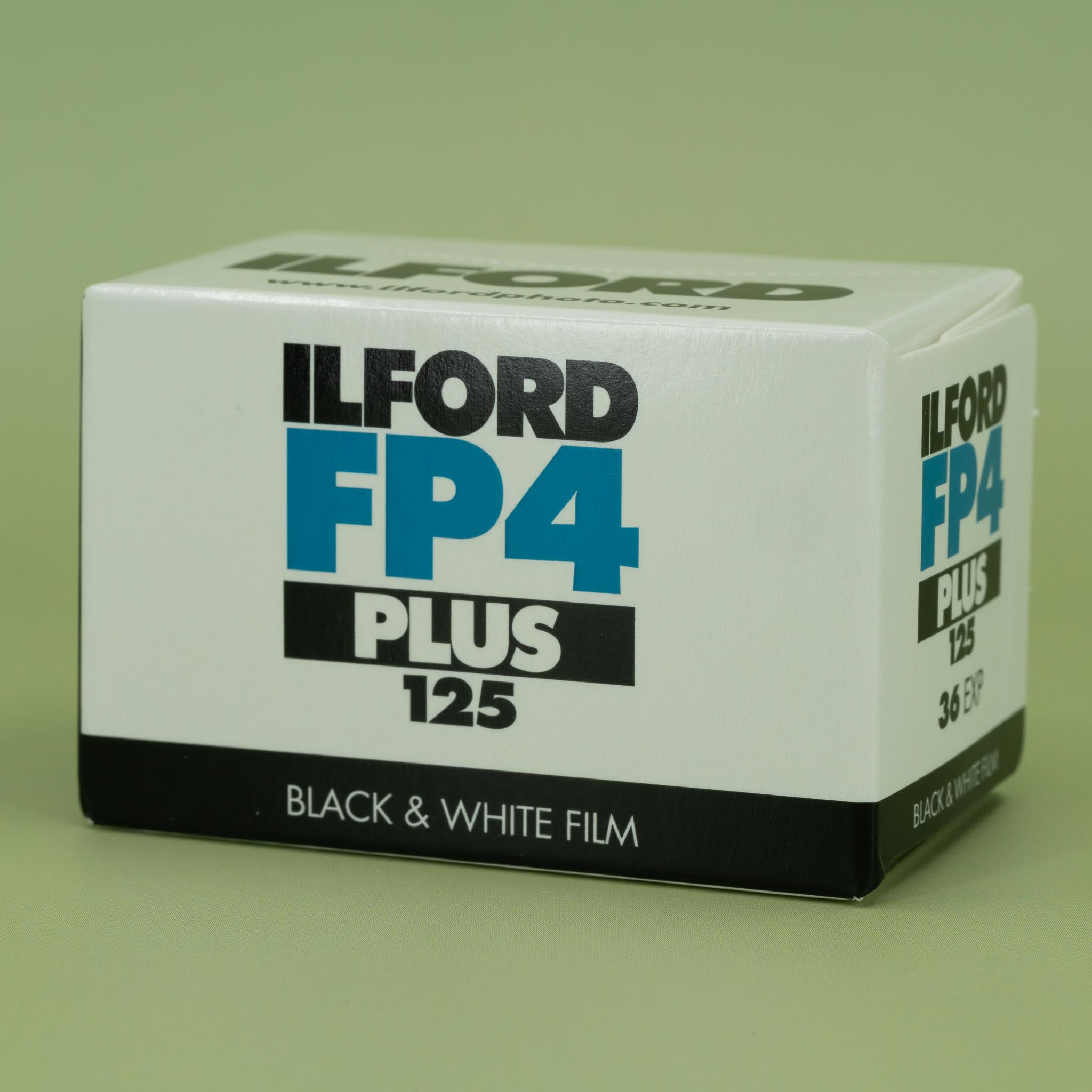Ilford FP4 Plus 125 black and white 35mm film box on a green background