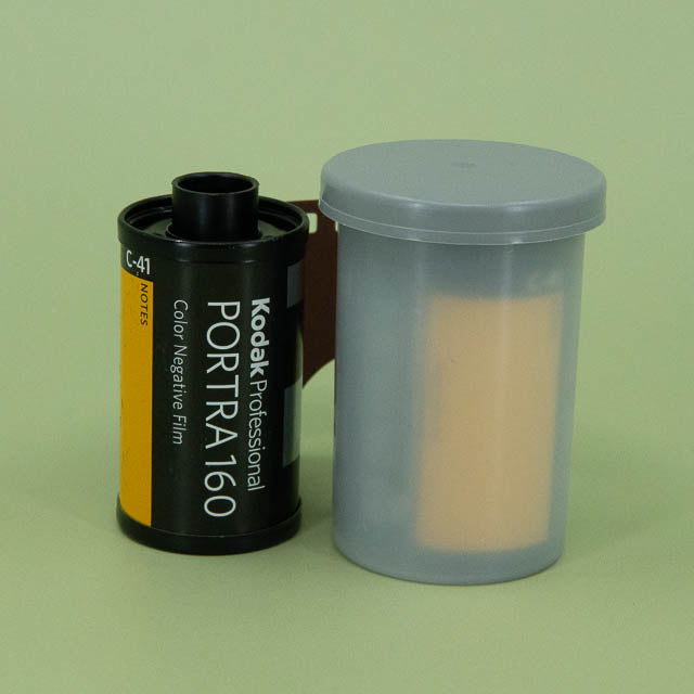 Kodak Portra 160 film canister with a gray container on a green background