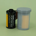 Kodak Portra 160 film canister with a gray container on a green background