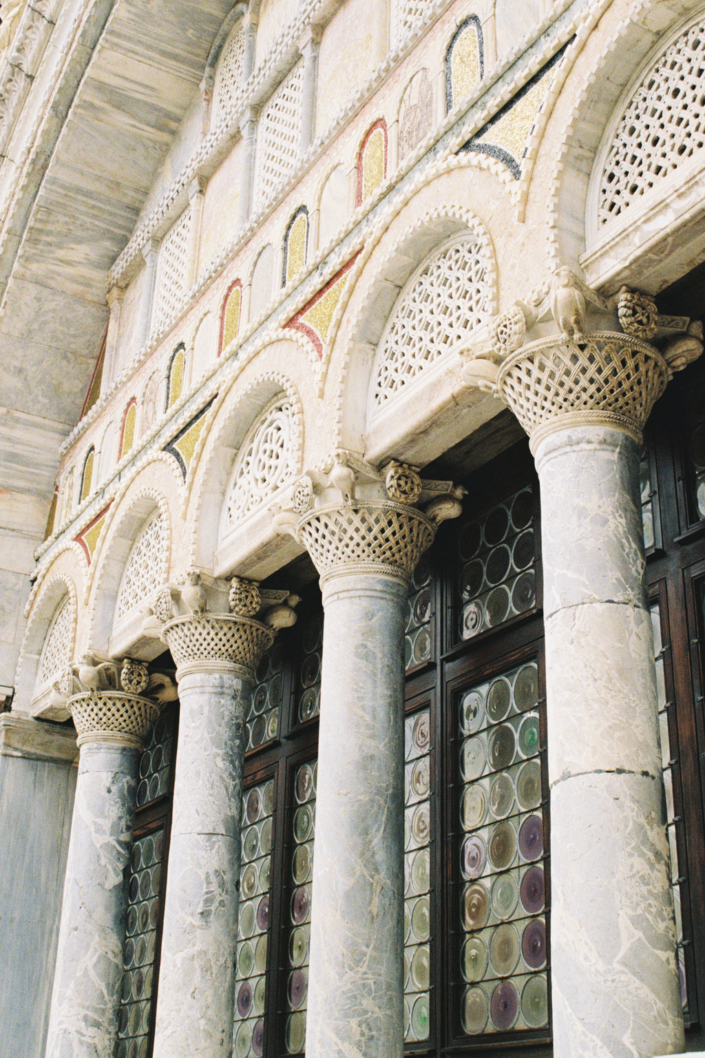 Decorative ceiling with intricate patterns and stained glass windows in a building.