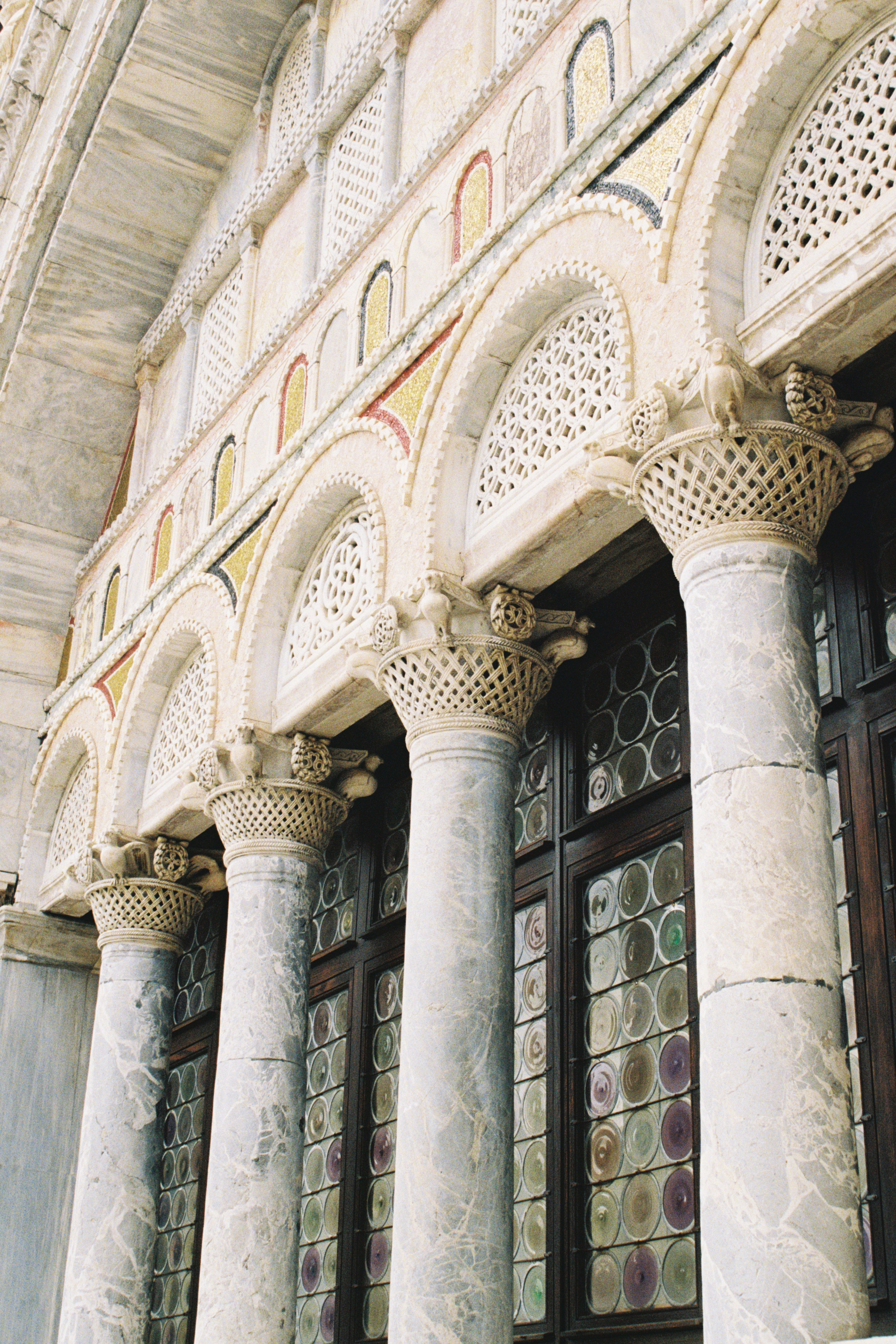 Decorative ceiling with intricate patterns and stained glass windows in a building.