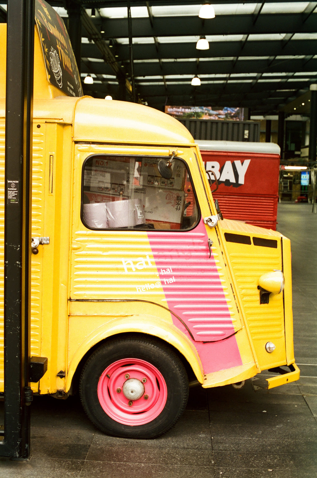 Yellow and pink truck with a red building in the background