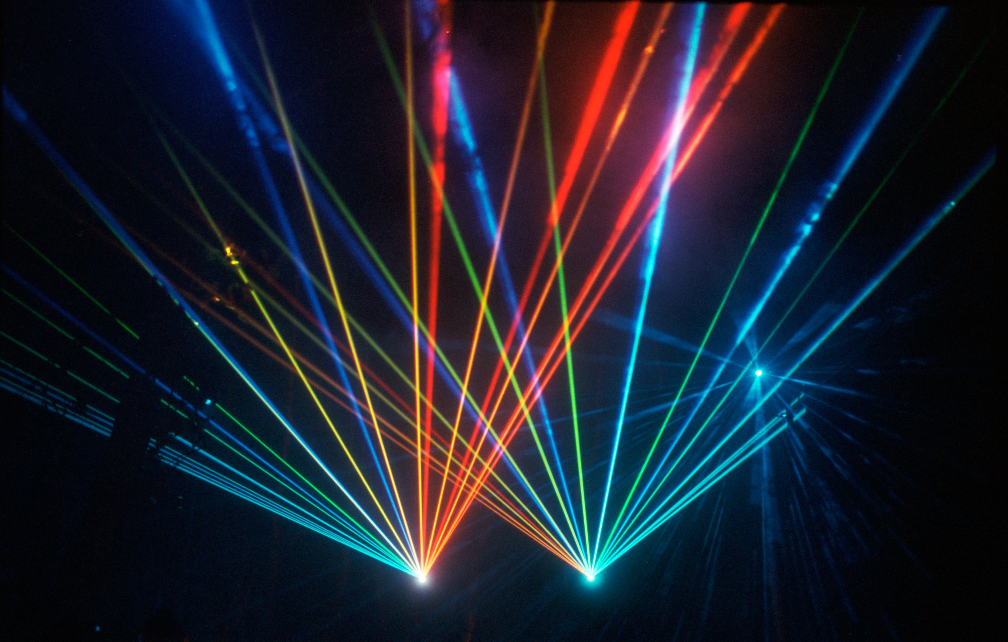 Colorful laser beams intersecting in a dark space