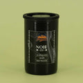 This is how I roll Noir 200 film canister on a green background