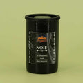 This is how I roll Noir 64 film canister on a green background